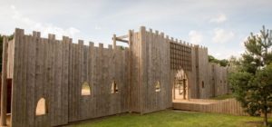The outside of the Adventure Castle playground. The entrance is made of wood and looks like a castle door.