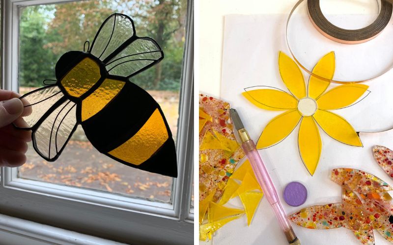 A stained glass bee being held up to a window and a flower in the process of being made.