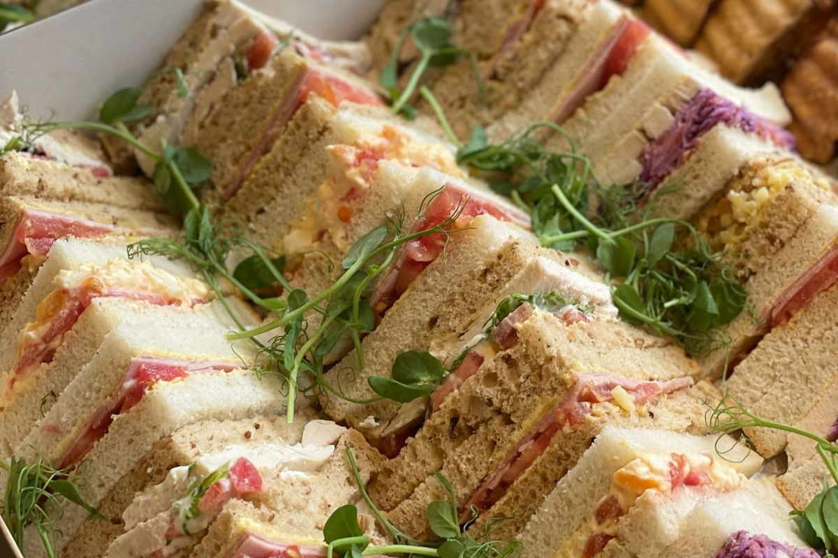 A selection of triangle cut sandwiches on a platter.