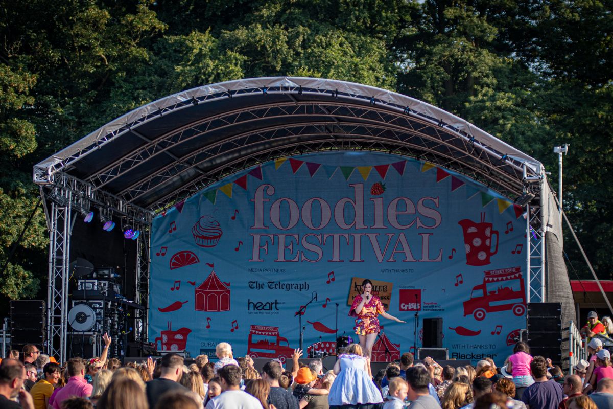 The Foodies Festival stage with a crowd of people in front.