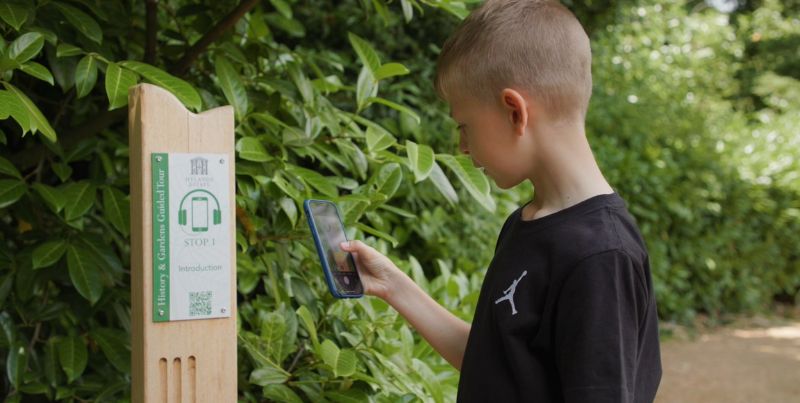 A young boy scanning a QR code on the Hylands History and Gardens Multimedia Tour.