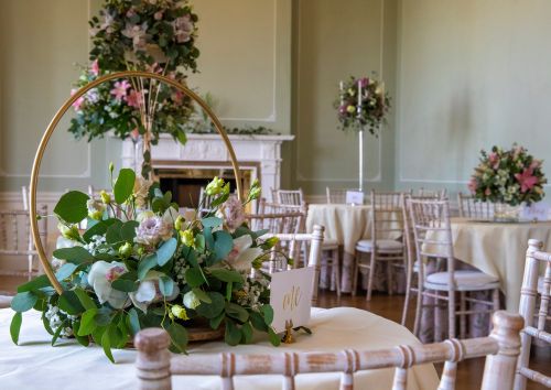 Pink and green floral centrepieces adorn small round tables in the Terrace Room.