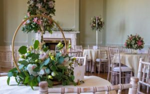 Pink and green floral centrepieces adorn small round tables in the Terrace Room.