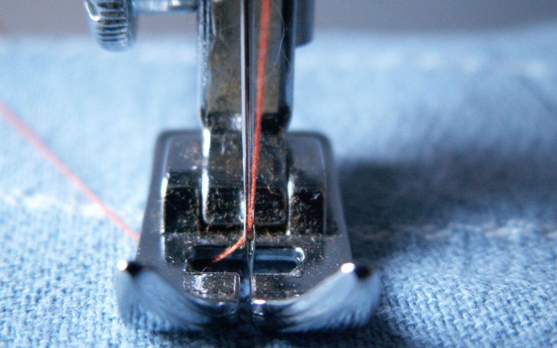 A closeup of a sewing needle going into fabric.