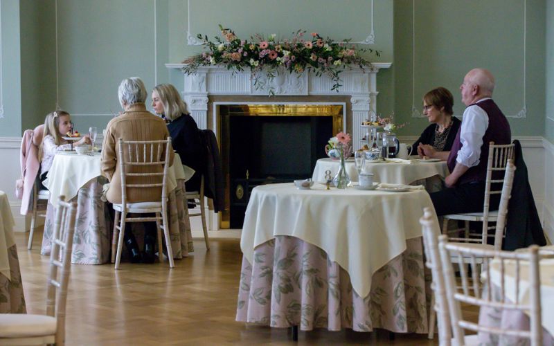 The Terrace Room set for afternoon tea with small round tables.