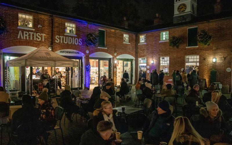 The Stables courtyard full of people with a band playing under a gazebo.