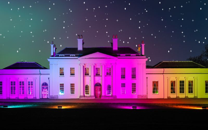 The front of Hylands House lit up with pink lights.