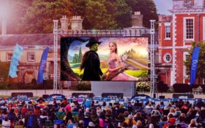 Wicked showing on a large outdoor screen.