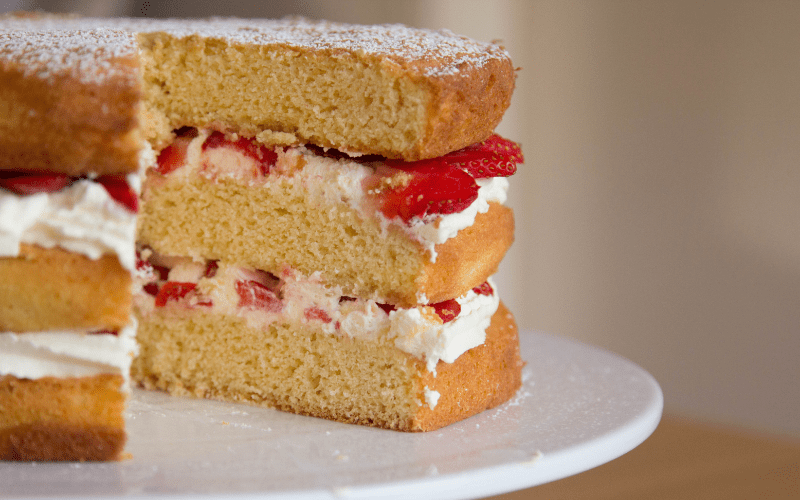 Victoria sponge cake with a slice taken out.