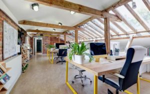 A large studio space with chairs and desks.