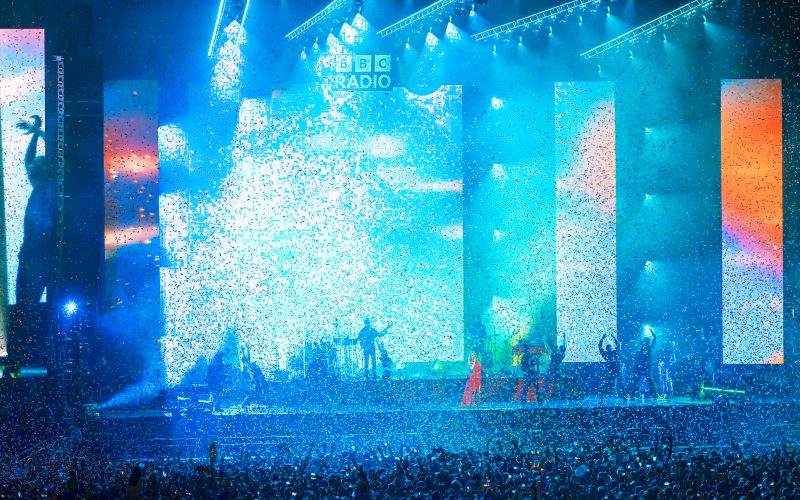 A large stage with musicians lit up in blue lights.