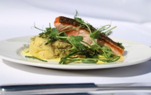 Salmon and potatoes on a white plate.