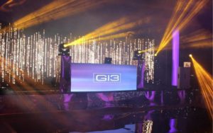 G13 Music DJ booth on a stage with up lighting.