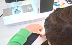 A child using a sewing machine.