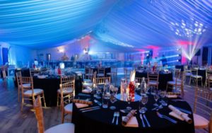 Round tables in the Grand Pavilion set with festive décor.