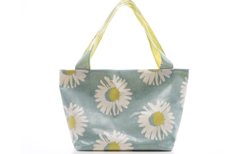 A handbag featuring white daisies on a blue background.